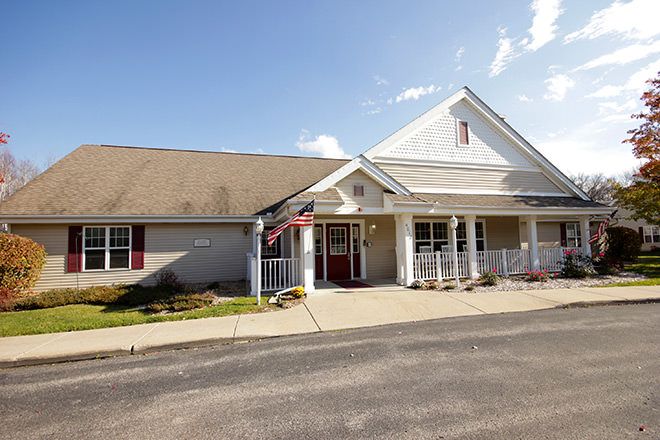 A suburban building with a front porch and pitched roof, captured on a sunny day.