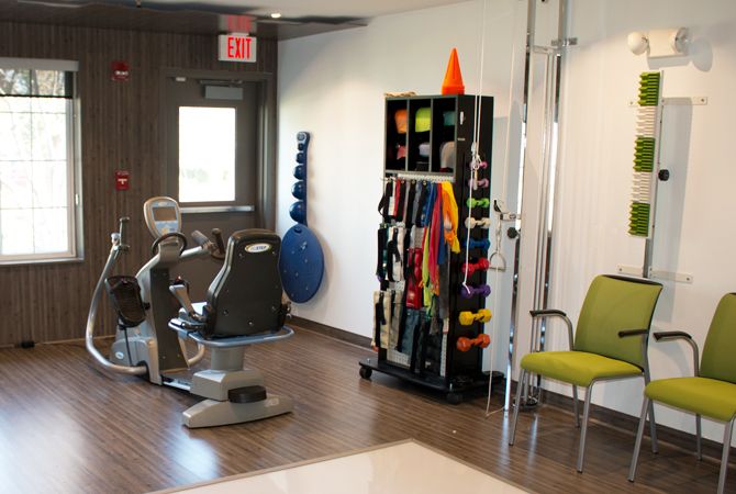 A fitness center with various exercise equipment and therapy tools.