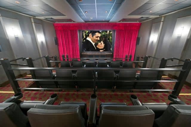 A luxurious home theater featuring comfortable seating and a large movie screen.