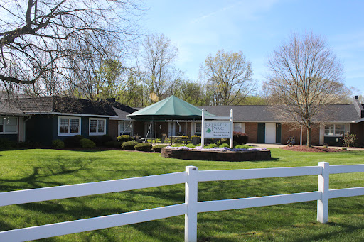 A picturesque view of a charming residence with a gazebo and well-maintained lawn.