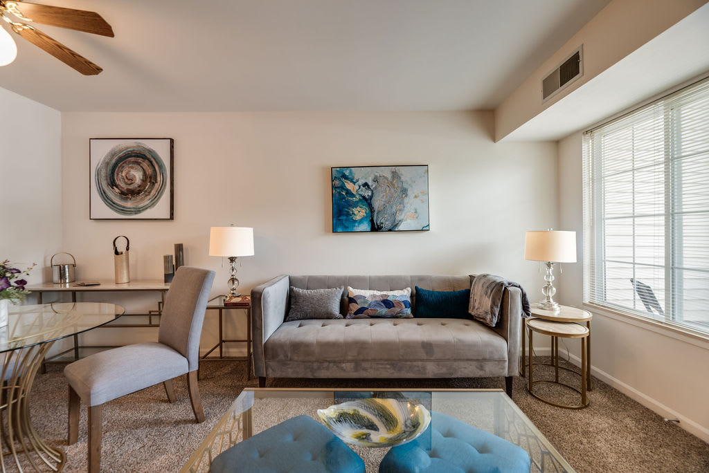 A modern living room with a stylish sofa, decorative artwork, and elegant lighting.