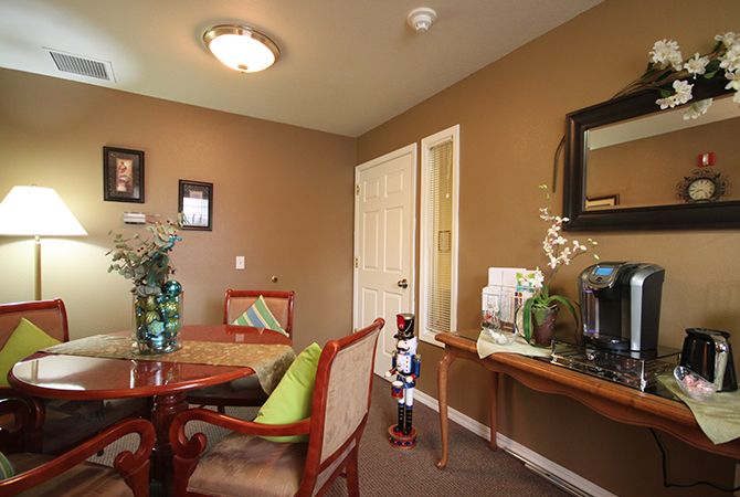 A cozy dining area with a round table, chairs, and decorative plants.
