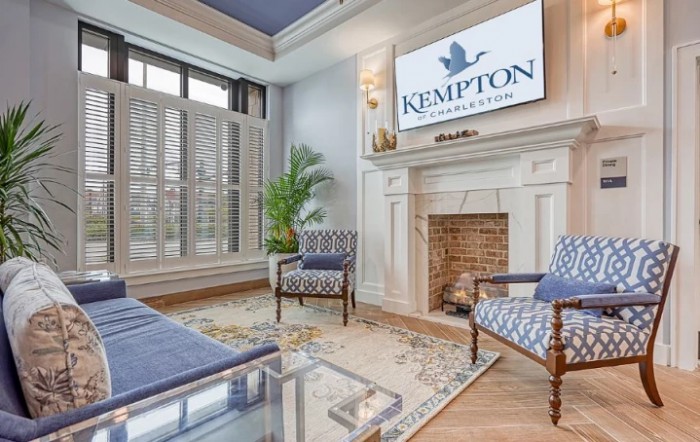 A stylish hotel lobby featuring elegant furniture and a fireplace.