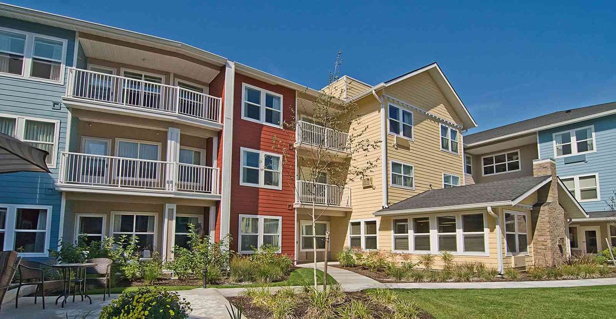 A modern apartment building with balconies and landscaped surroundings.