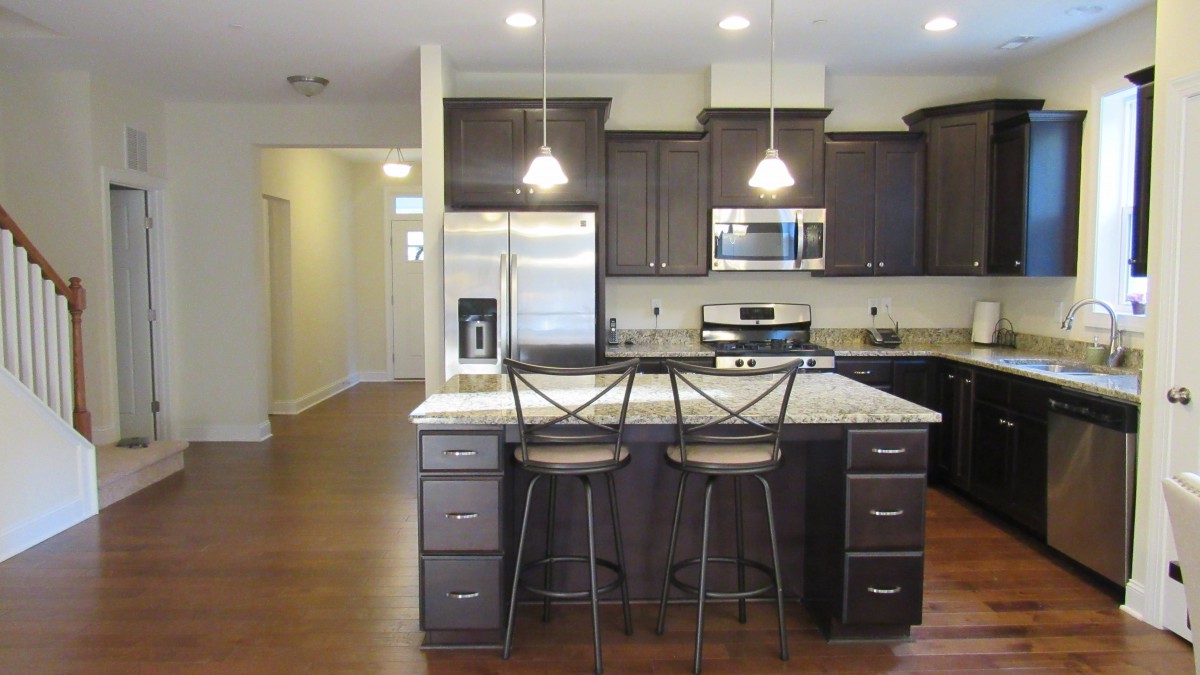 A modern kitchen featuring an island with bar stools and stainless steel appliances.