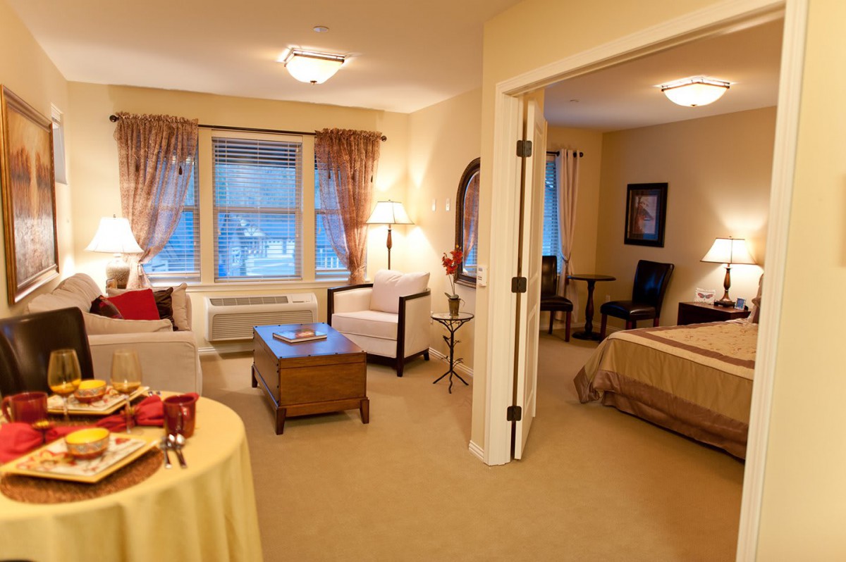 A cozy apartment interior featuring a living room with comfortable seating and an adjacent bedroom.