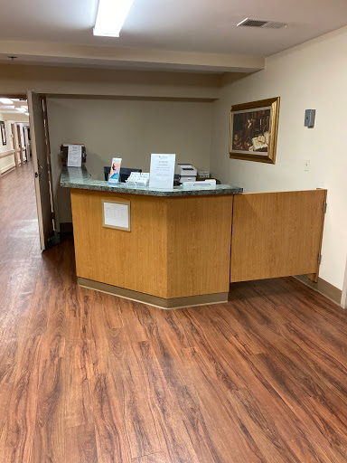 A well-lit reception area with a wooden desk and a welcoming atmosphere.