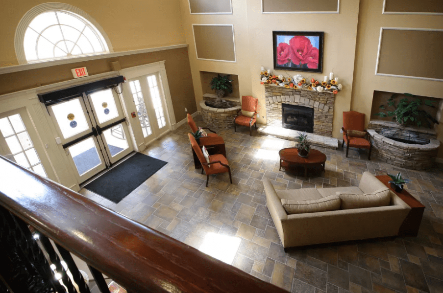 A cozy lobby area with comfortable seating, a fireplace, and a television.