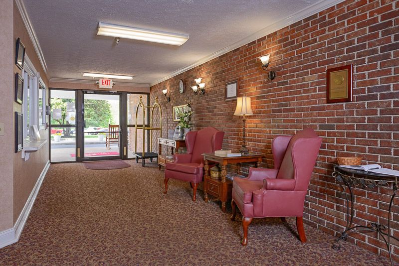 Cozy lobby area with brick walls, comfortable chairs, and warm lighting.