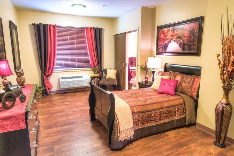 A cozy and well-decorated bedroom with a wooden floor, stylish furniture, and vibrant curtains.
