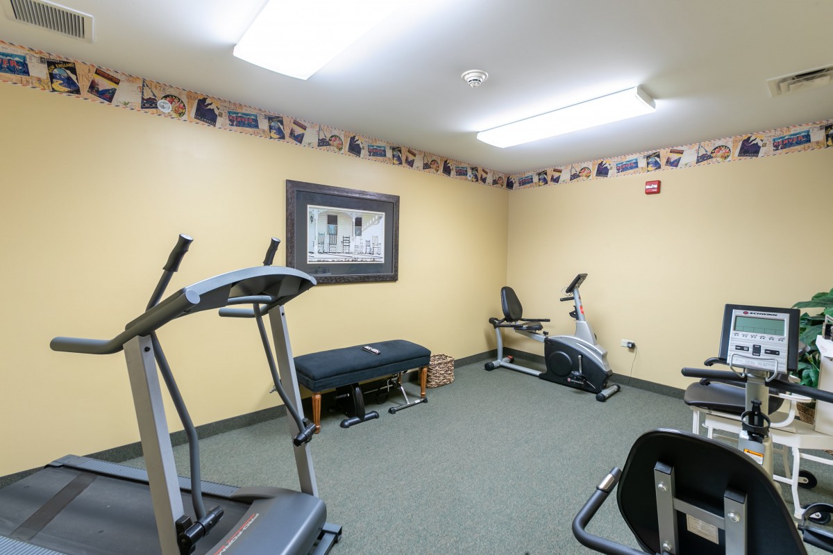 A small fitness room equipped with a treadmill and an exercise bike.