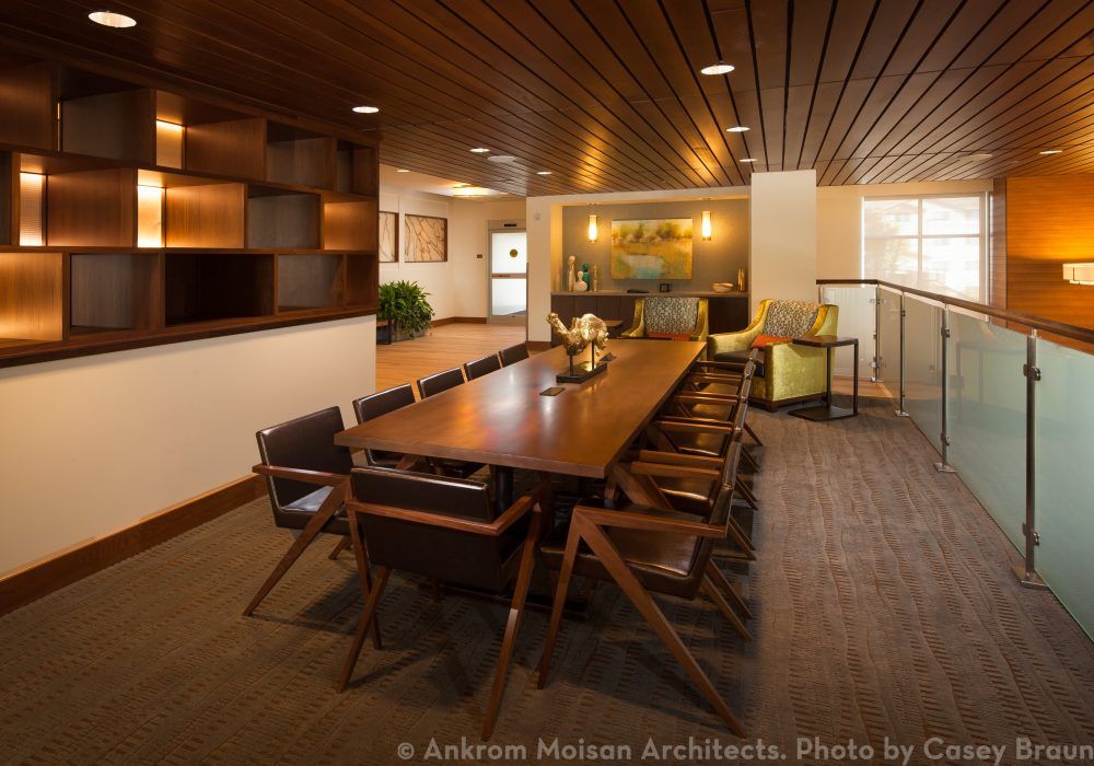 A modern conference room with a large wooden table and stylish chairs.