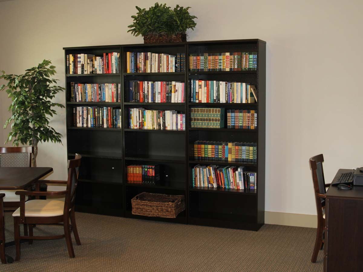 A cozy reading area featuring a large bookshelf filled with books.