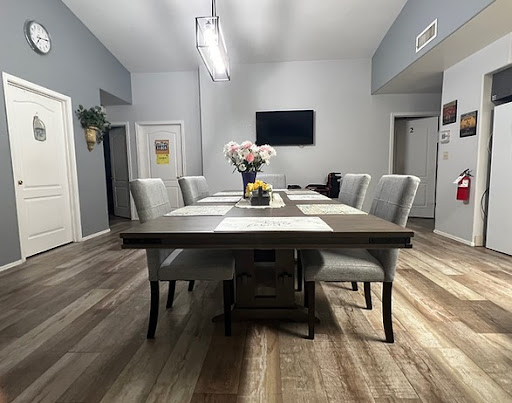 A spacious and modern dining room featuring a large table, comfortable chairs, and tasteful decor.