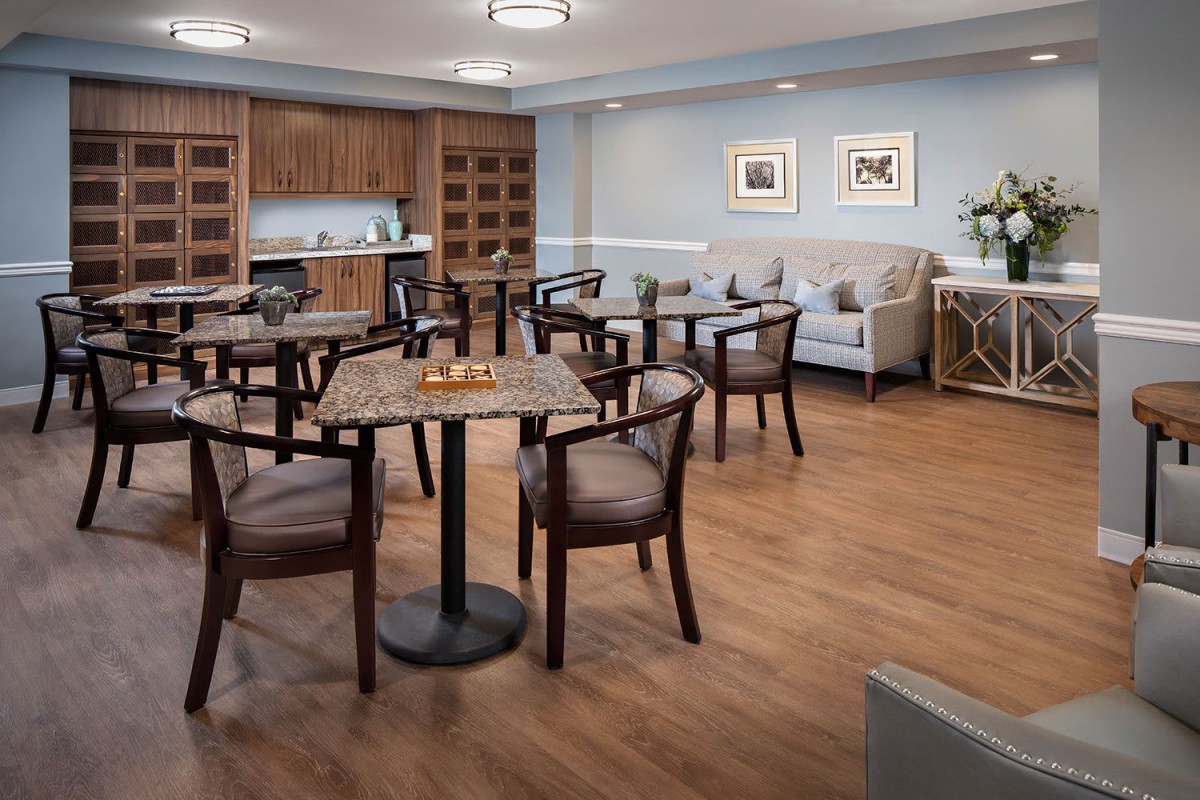 A cozy dining area with wooden tables and chairs, set in a room with warm wood flooring and comfortable decor.