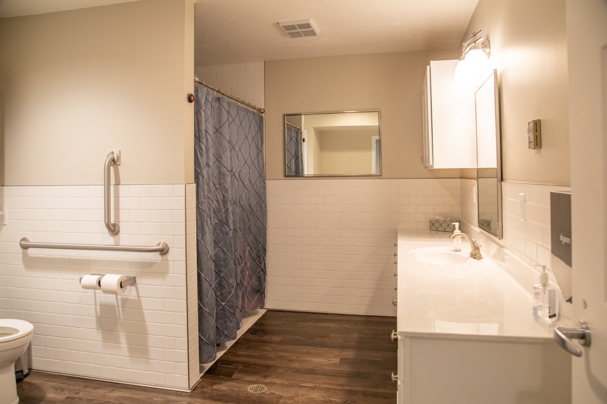 A modern bathroom with a shower, mirror, and double sink.