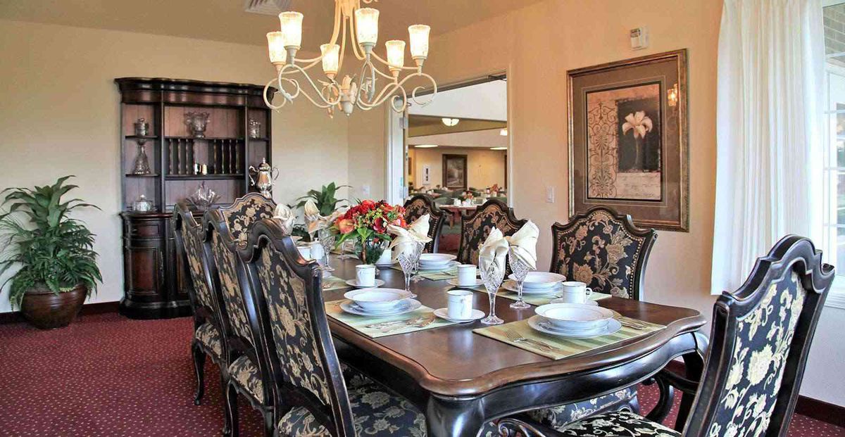 Elegant dining room with a beautifully set table and chandelier lighting.
