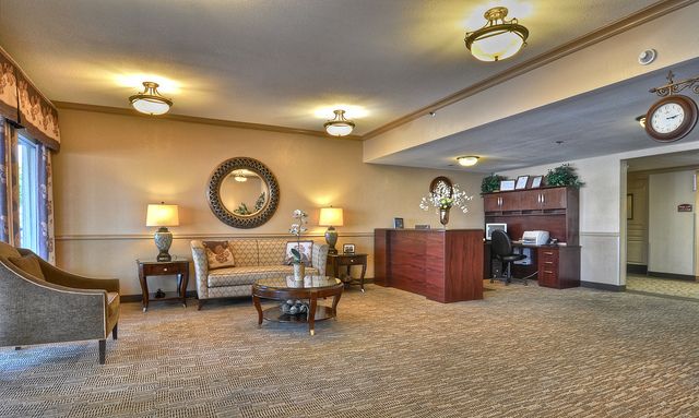 A spacious and elegantly designed lobby featuring comfortable seating, decorative mirrors, and ambient lighting.