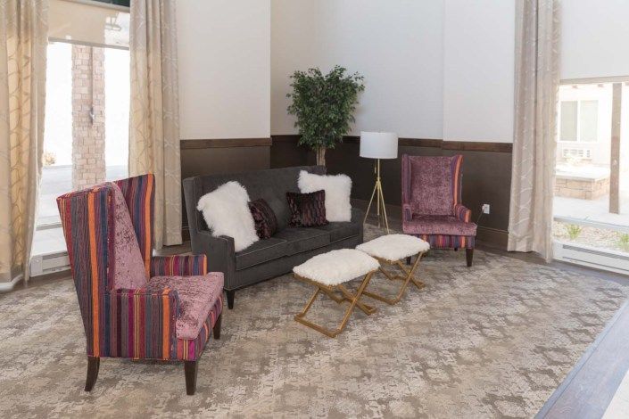 A cozy living room with a stylish sofa, colorful chairs, and elegant decor.