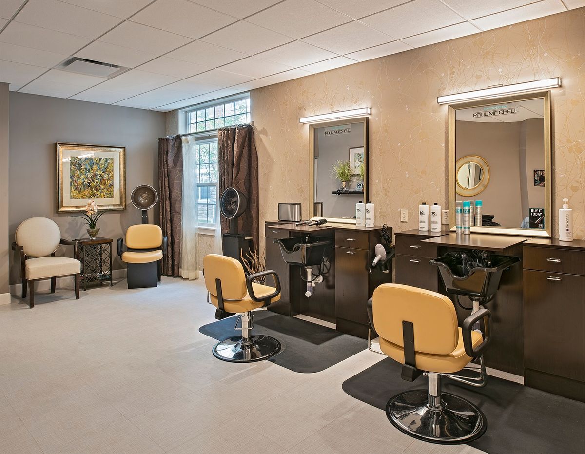 A modern beauty salon with styling chairs and mirrors.