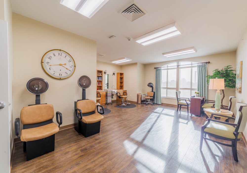 A bright and spacious hair salon with chairs and dryers under natural light.