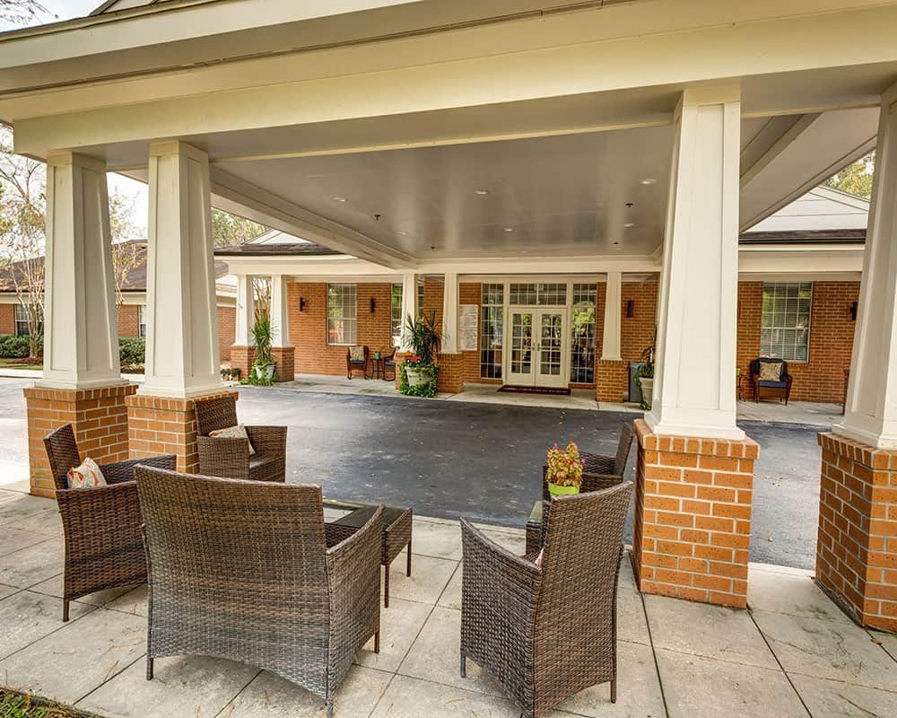 Outdoor seating area at the entrance of a building with columns.