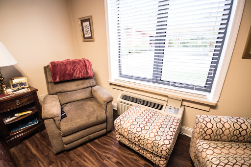 A cozy corner featuring a recliner and an ottoman by the window.