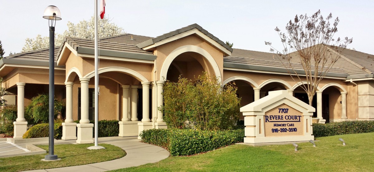 A house with classical architecture, featuring columns and a well-maintained garden.