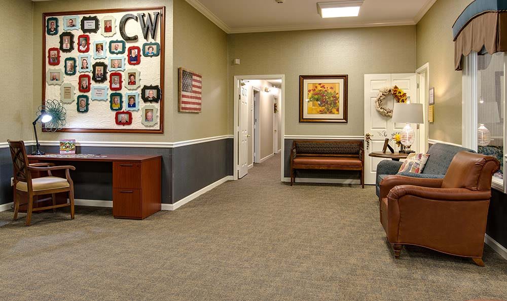 A cozy waiting room with seating and artwork on the walls.