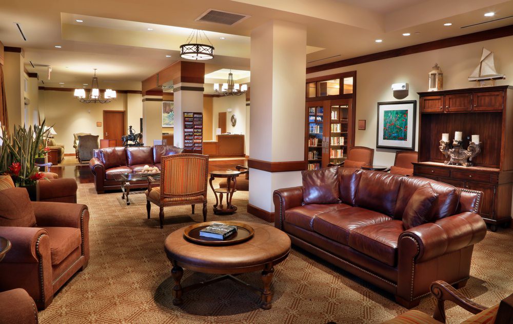 A cozy lobby area with leather sofas, elegant lighting, and warm-toned furnishings.