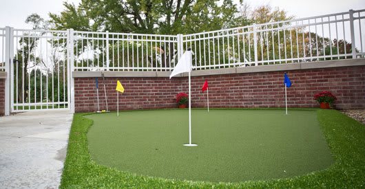 A mini golf putting green with colorful flags set up outdoors.