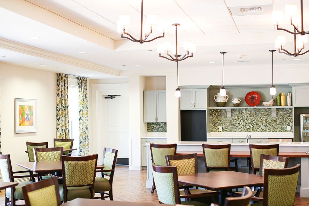 A modern dining area with elegant lighting, tables, and chairs.