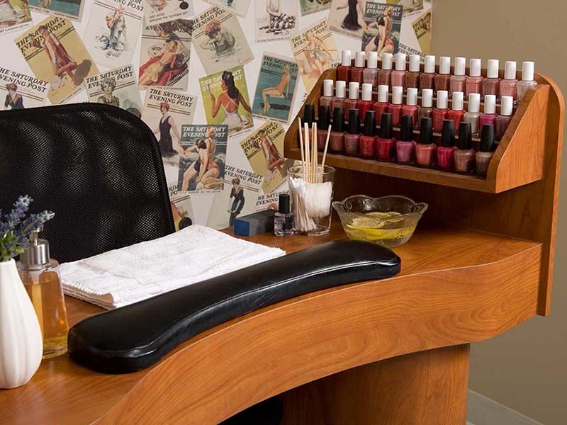 A manicure station in a nail salon with an array of nail polish bottles and tools.