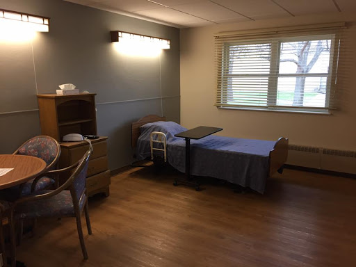 A simple and clean hospital patient room with two beds and a window.