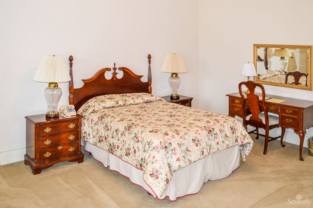 A traditional bedroom with a wooden bed and matching furniture.