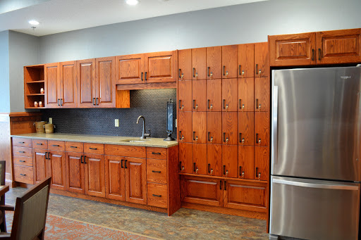A beautifully designed modern kitchen featuring wooden cabinets, a sleek sink, and a stainless steel refrigerator.
