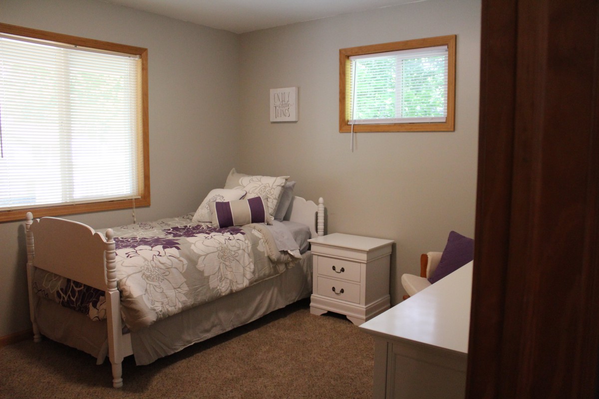 A cozy bedroom with a single bed and neutral decor.