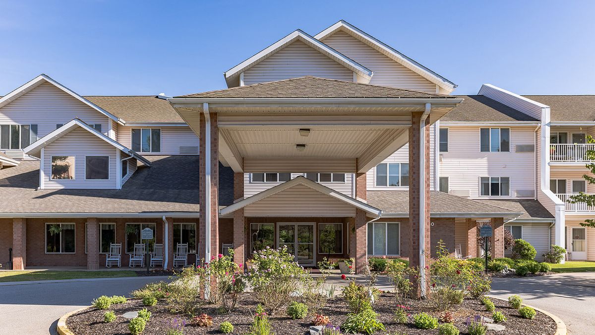 A residential building with a landscaped entrance and covered entryway.