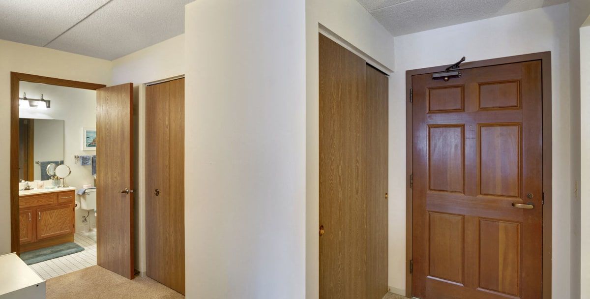 A view of a hallway featuring three wooden doors.
