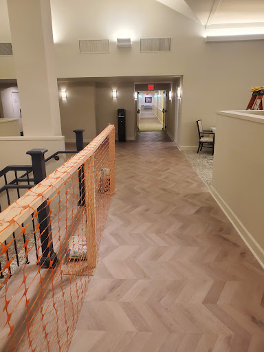 A well-lit interior hallway featuring herringbone flooring and modern decor.