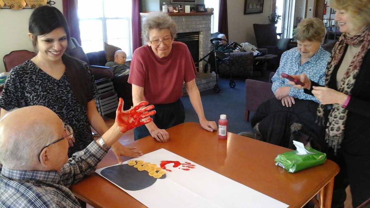 A group of people engage in a collaborative art project indoors.