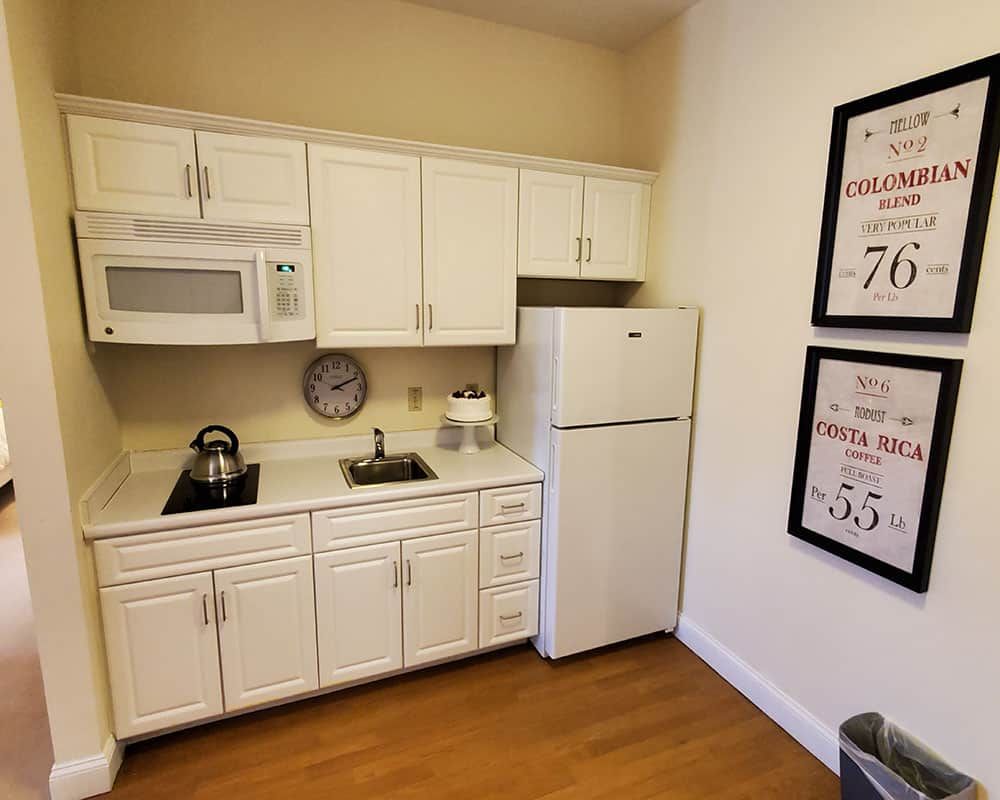 Compact kitchen with white cabinets and modern appliances.