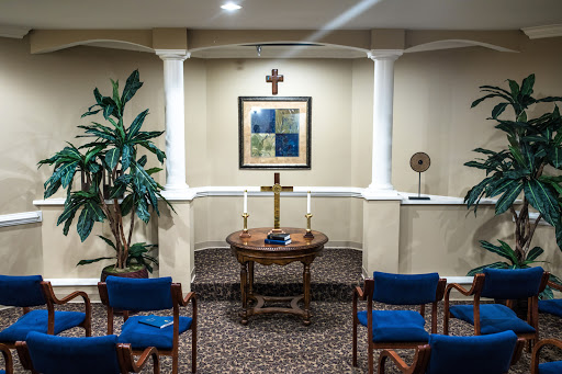 A serene chapel setting with a cross, comfortable seating, and decorative elements, ideal for reflection and prayer.