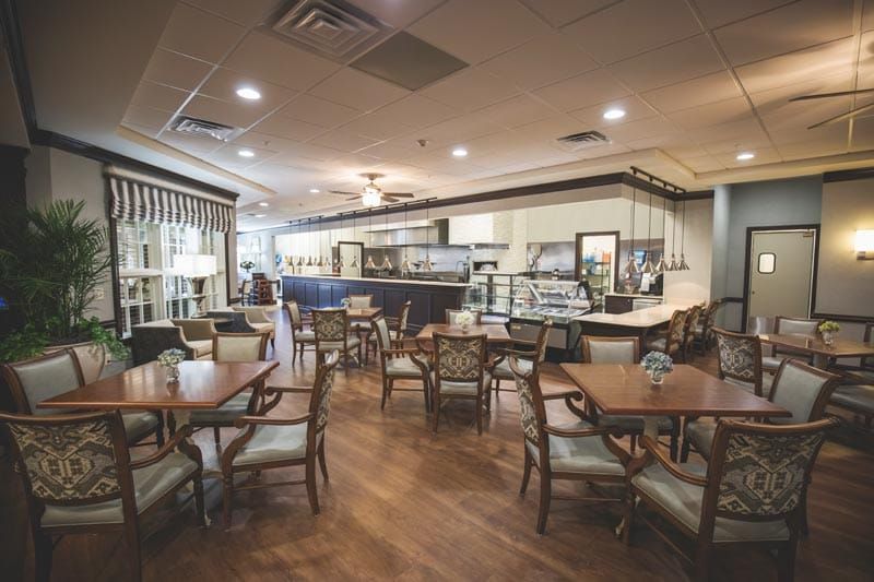A cozy cafe interior with wooden floors and neatly arranged tables and chairs.
