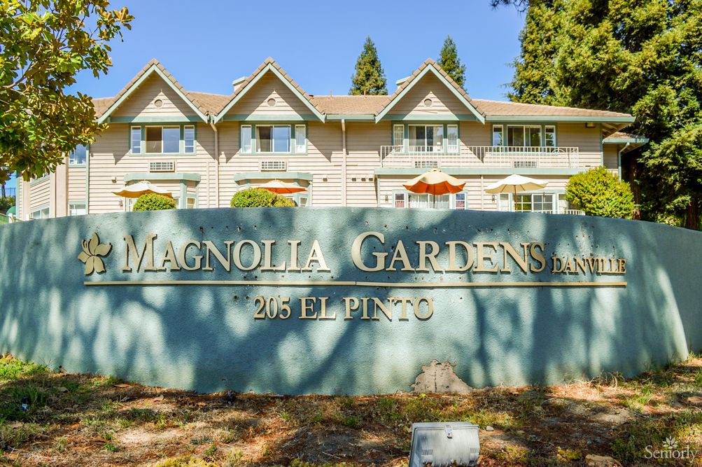 A residential apartment complex with a sign reading 'Magnolia Gardens, 25 El Pinto'.
