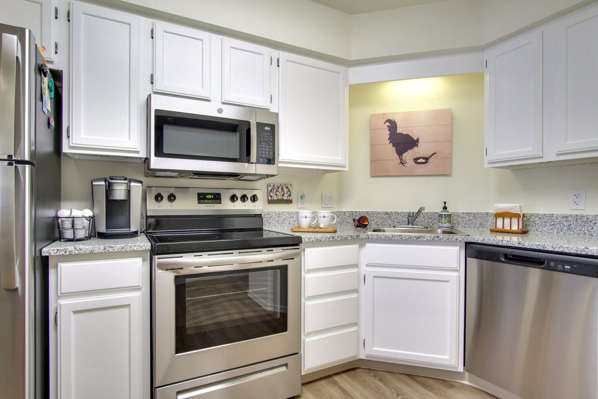 A modern kitchen with stainless steel appliances and white cabinets.