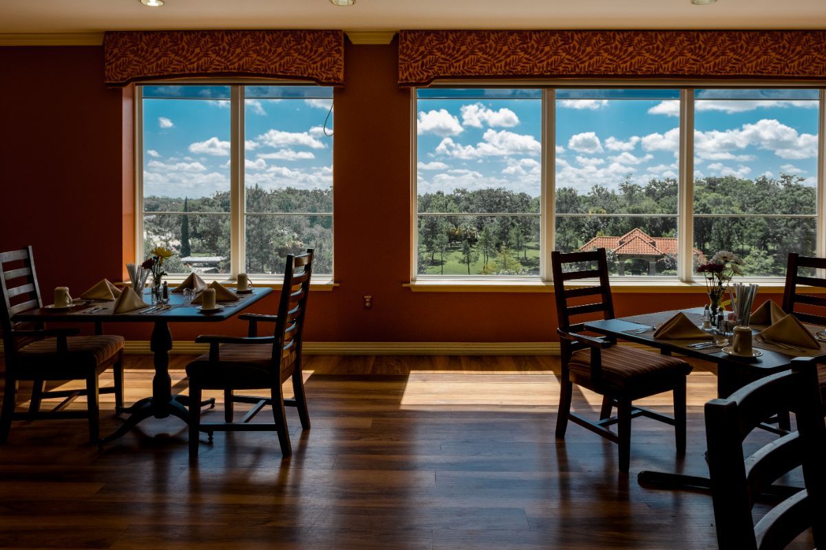 A well-lit dining room with large windows offering a scenic outdoor view.