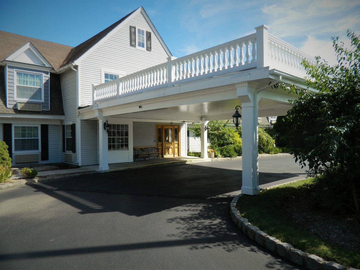 A residential building with an elevated porch and a driveway.