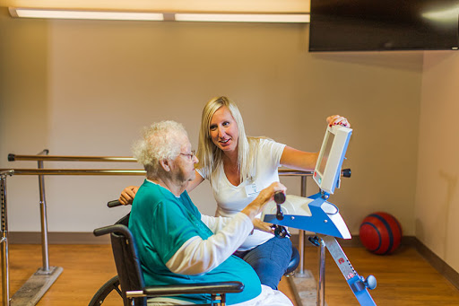 A caregiver assists an elderly individual in a rehabilitation session, fostering engagement and support.