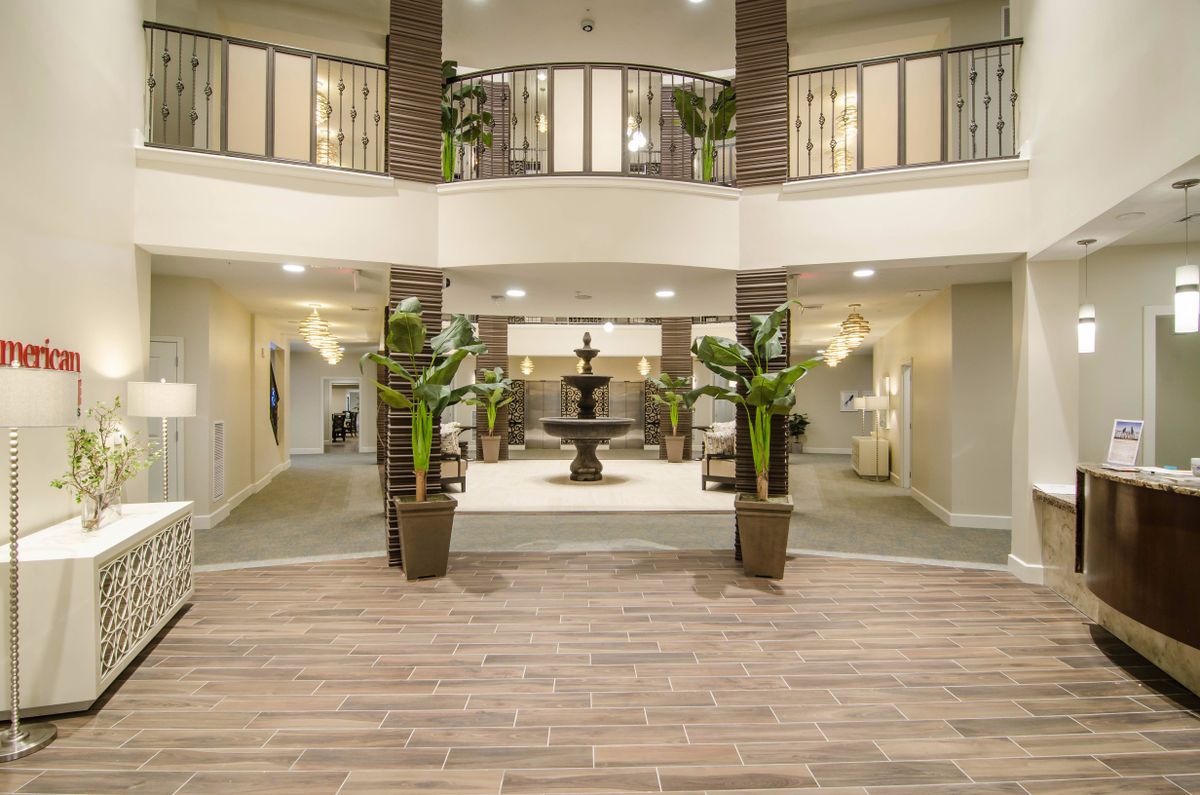 A luxurious hotel lobby featuring a central fountain and elegant decor.
